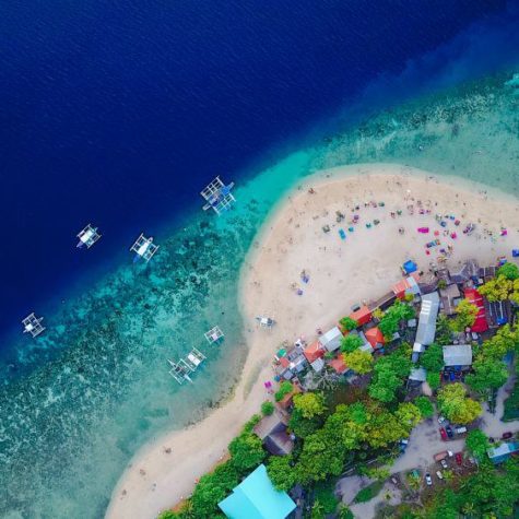 Aerial view of sandy beach with tourists swimming in beautiful c